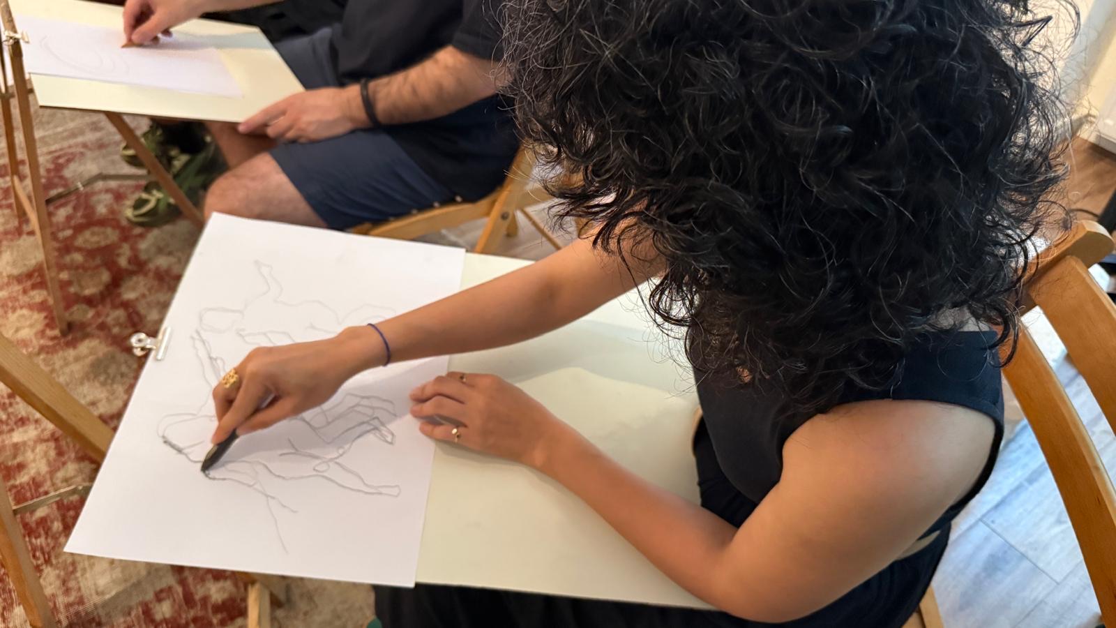 A participant making a figure drawing during a session