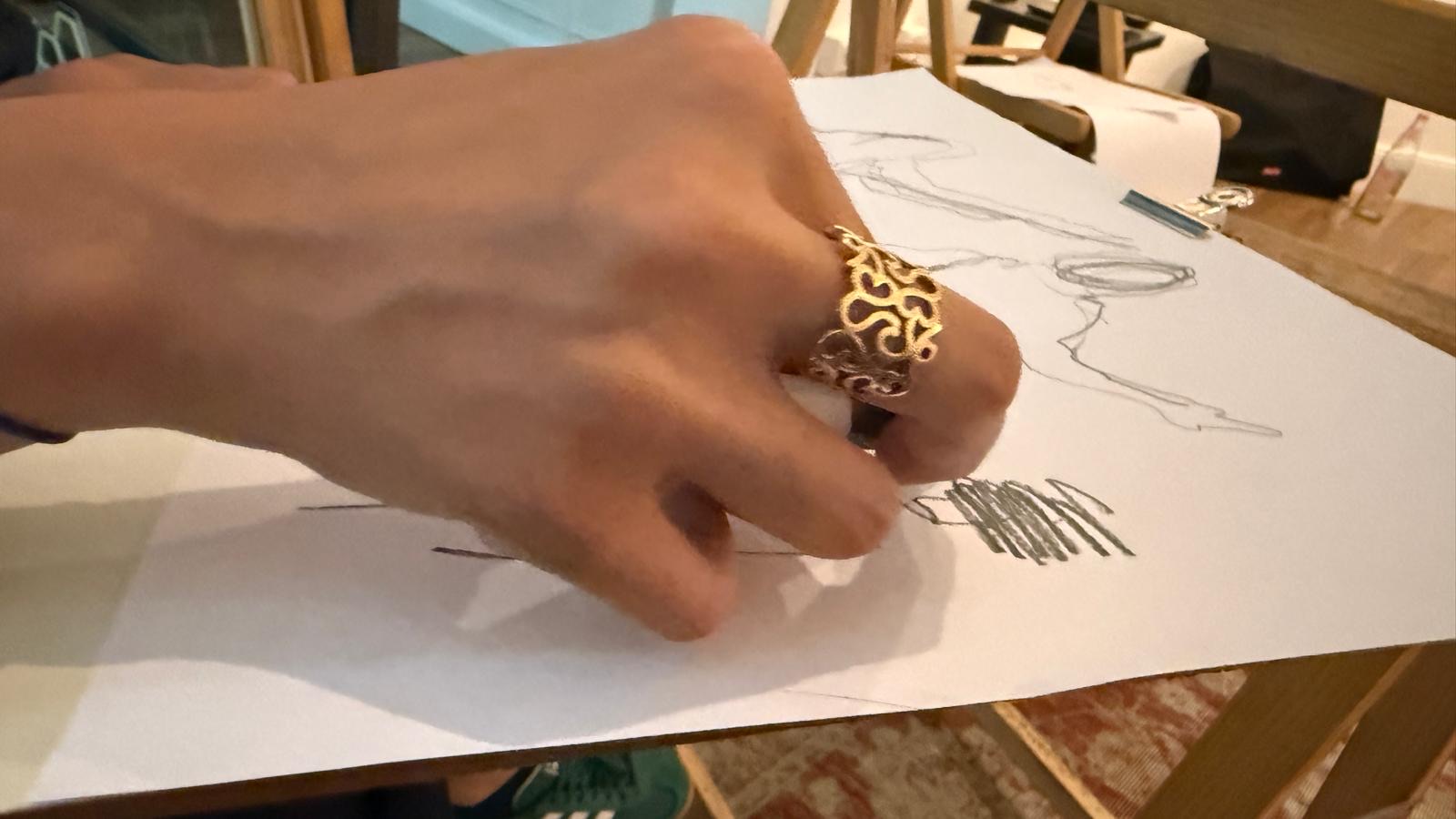 A close view of a participant drawing on paper