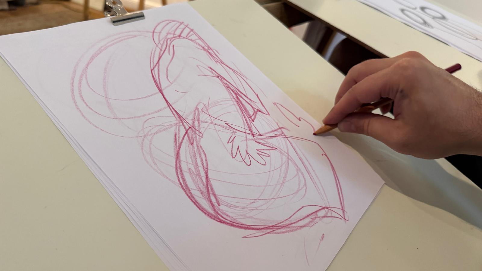 A close view of a red figure drawing being made